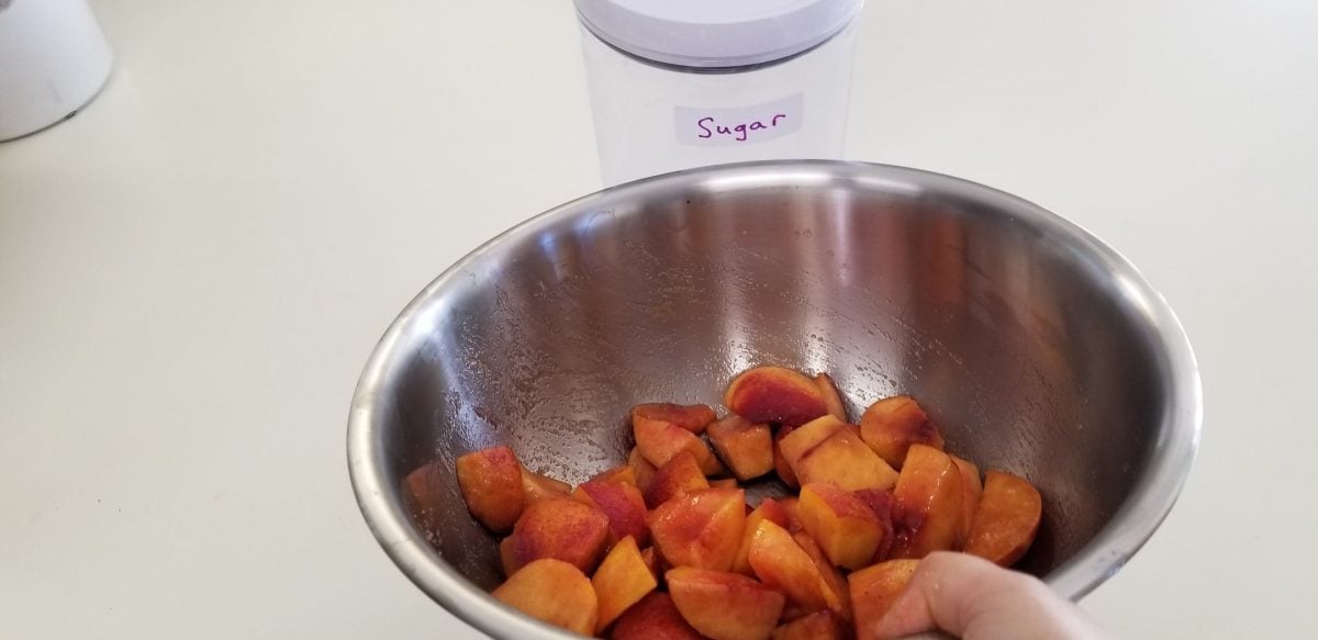 mixing nectarines with sugar for vegan pie filling